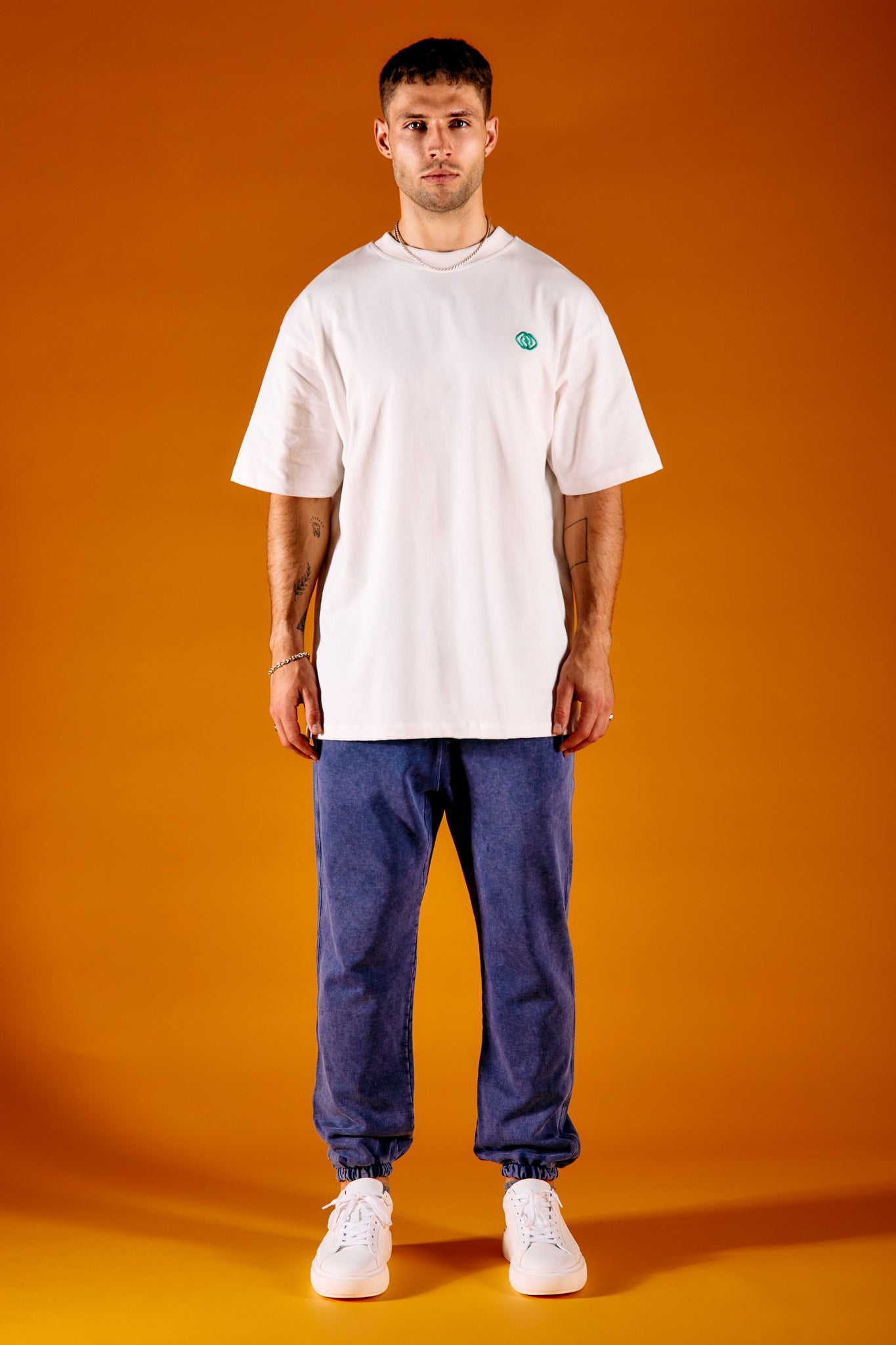 man wearing white heavyweight t-shirt and blue joggers