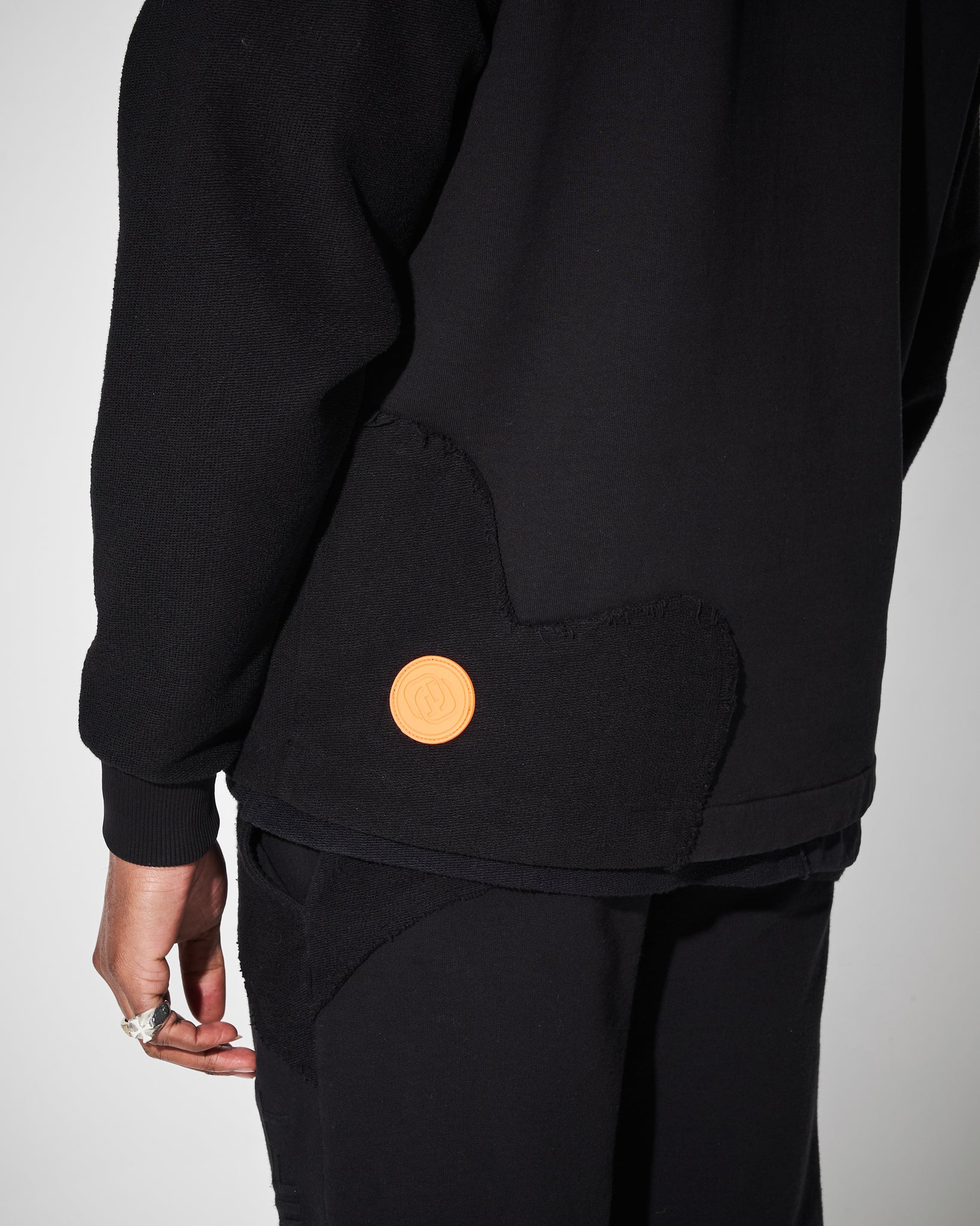 orange logo on lower back of heavyweight hoodie in black