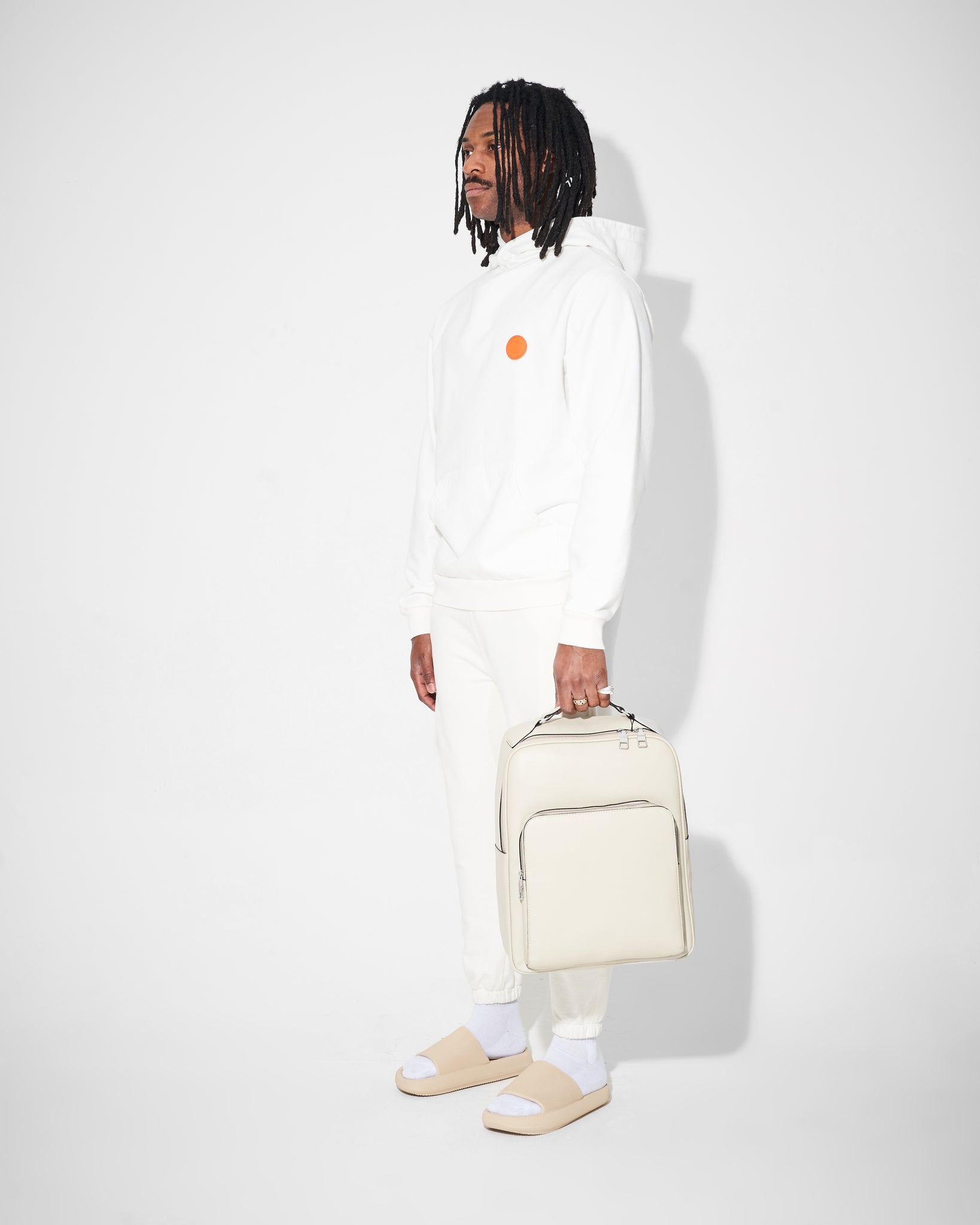 model wearing white heavyweight joggers and tracksuit hold backpack